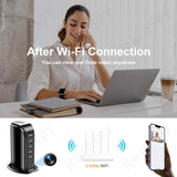 Woman using laptop near 5-port USB charging tower spy cam with Wi-Fi connection for real-time video monitoring.